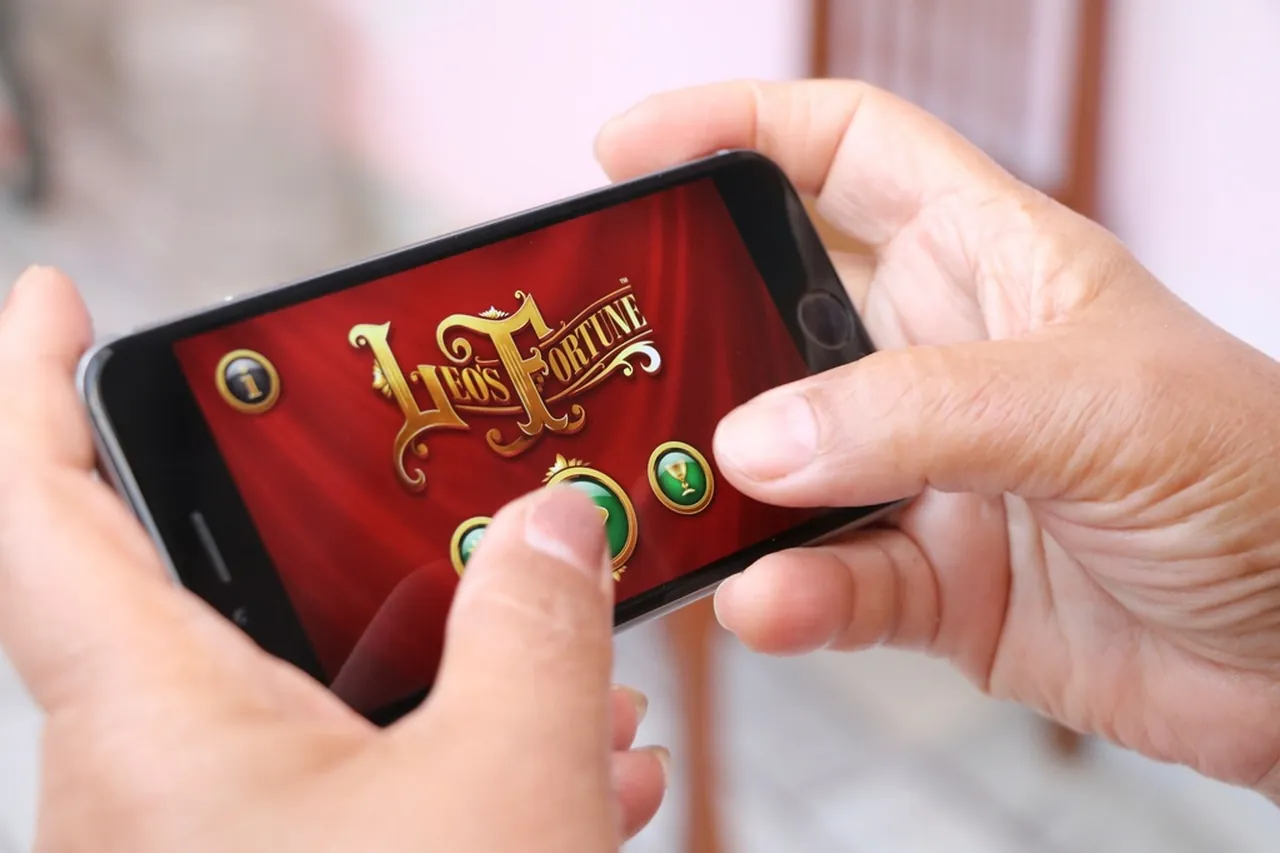 Händer som spelar ett casinospel på en mobiltelefon