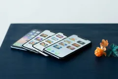 Fyra smartphones i en solfjäder på ett skrivbord